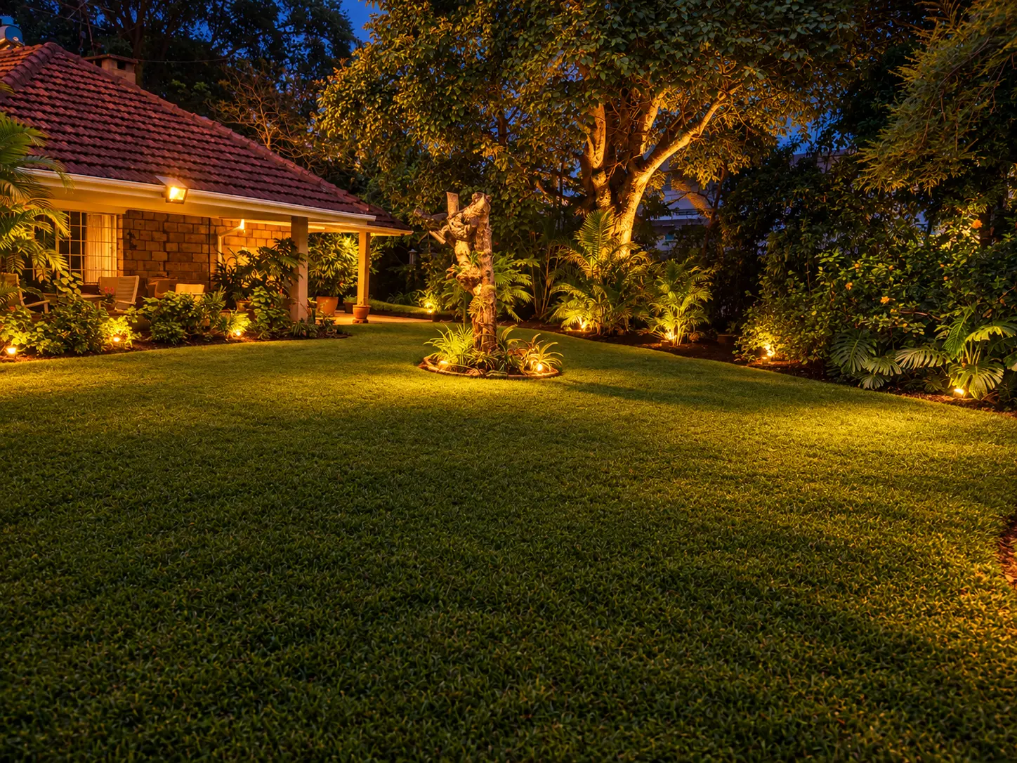 The backyard garden glowing with warm lights at dusk